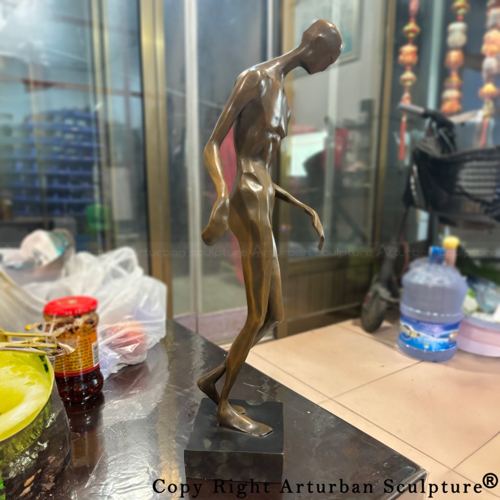 Bronze abstract human sculpture placed on table