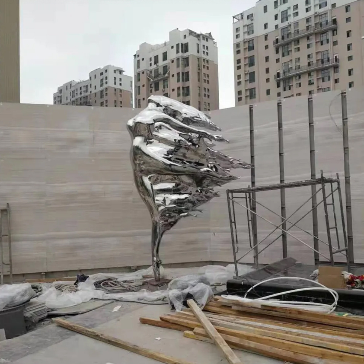 A stainless steel Woman in the Wind Statue featuring a woman with one leg lifted backward and wind-blown design