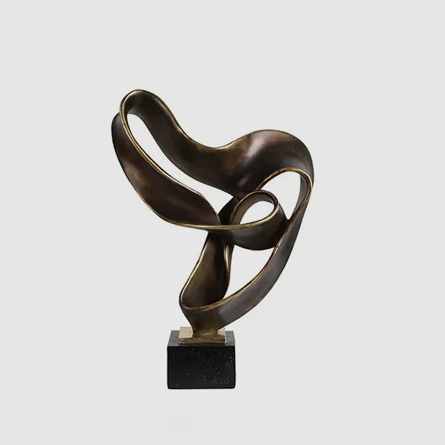 Abstraction in Sculpture with flowing ribbon-like bronze form on a black marble base
