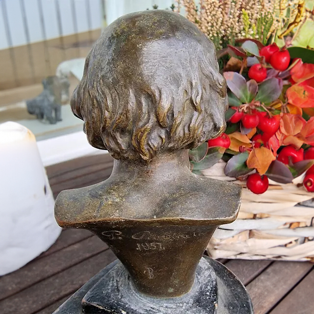 Back view of the bronze Male Head Bust sculpture showing engraved year 1857 and wavy hair details