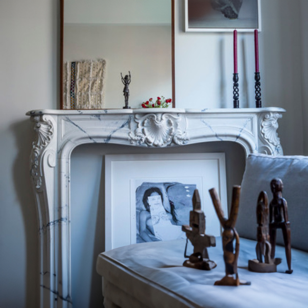 Classic Modern Marble Mantel installed in a modern room with candles, decor and artwork above