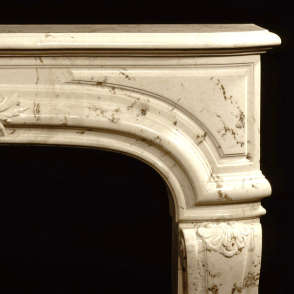 Corner detail of a cream Marble Mantel for Fireplace showing curved arch