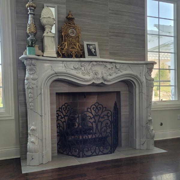 French-style Marble Mantel Surround installed in a modern living room, paired with ornate decor and iron fireplace screen
