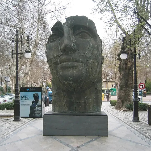 Full frontal display of a cracked Bronze Head Sculpture on a pedestal