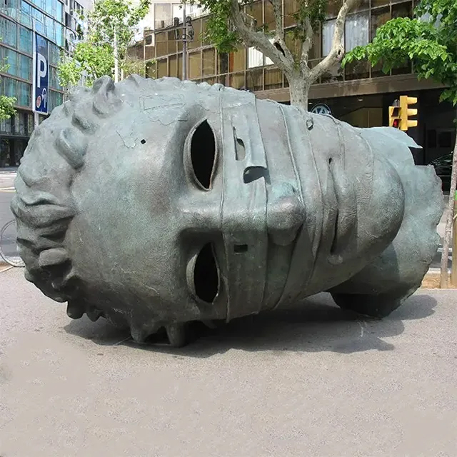 Mitoraj Eros Bendato bronze sculpture, depicting a giant bandaged classical head lying on the ground with hollow eyes