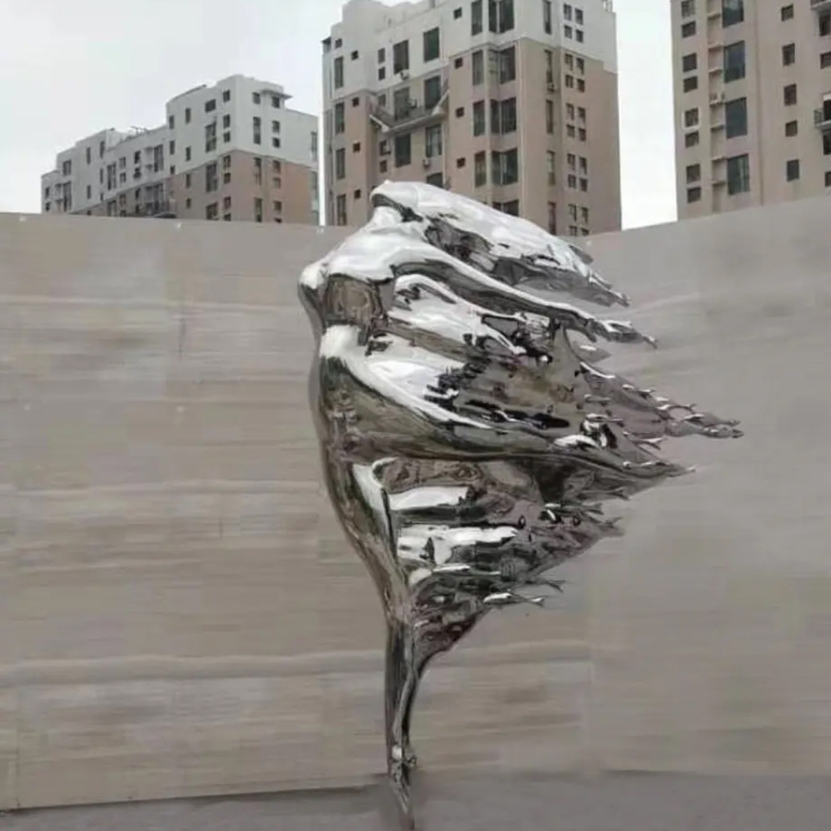 Outdoor display of a stainless steel Woman in the Wind Statue