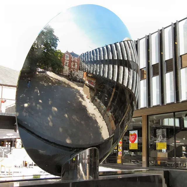 Stainless steel Sky Mirror Sculpture placed in an urban setting