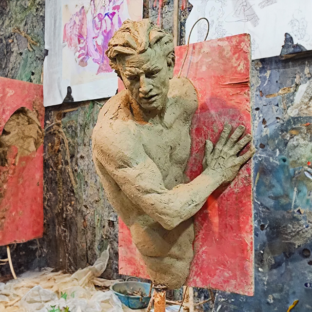 Studio view of Matteo Pugliese Art clay model showing male figure pushing through wall before bronze casting