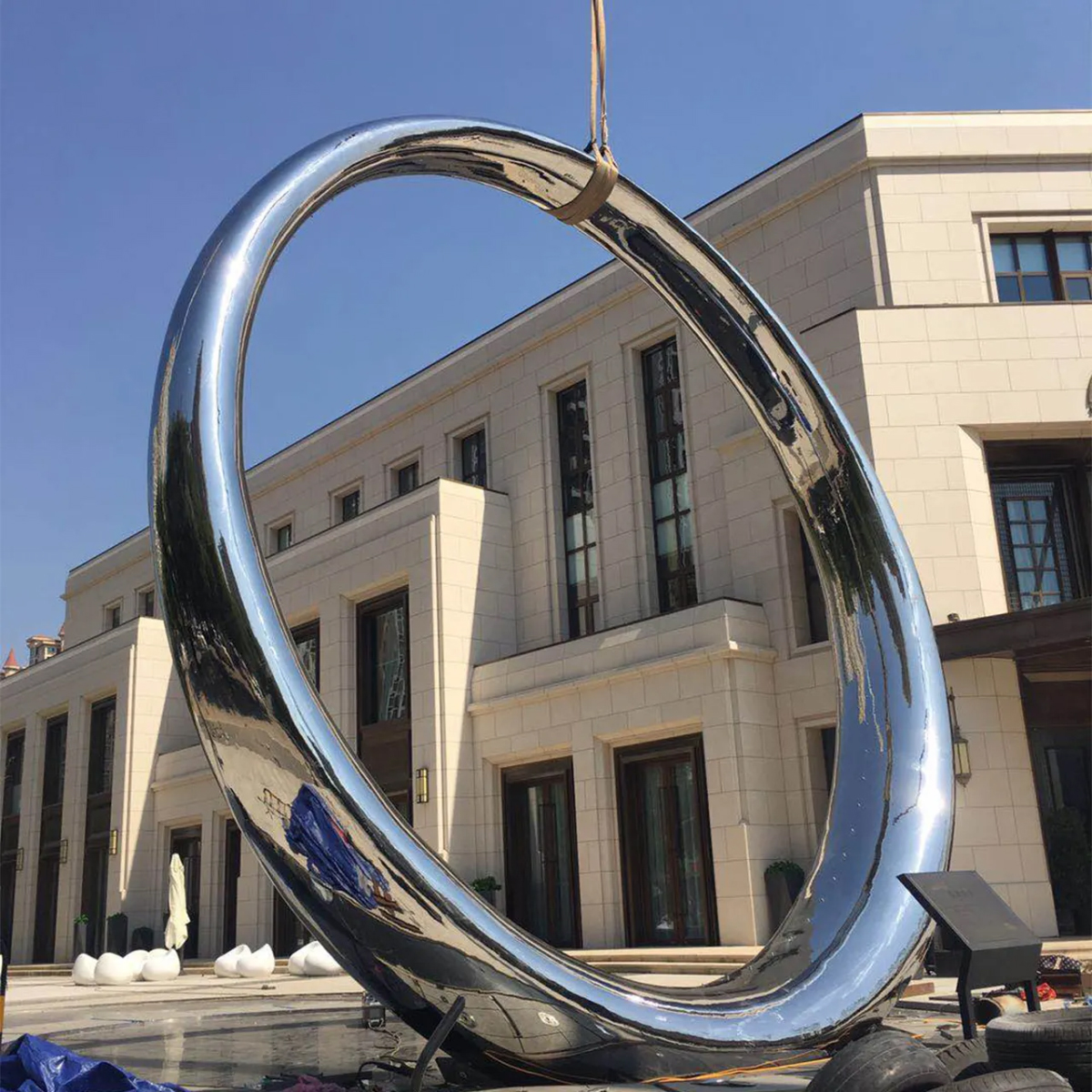 a large stainless - steel The Ring Sculpture being installed