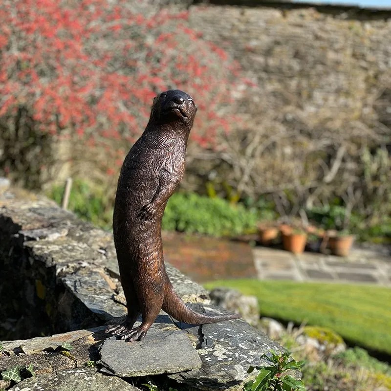 bronze Otter Garden Sculpture on stone edge