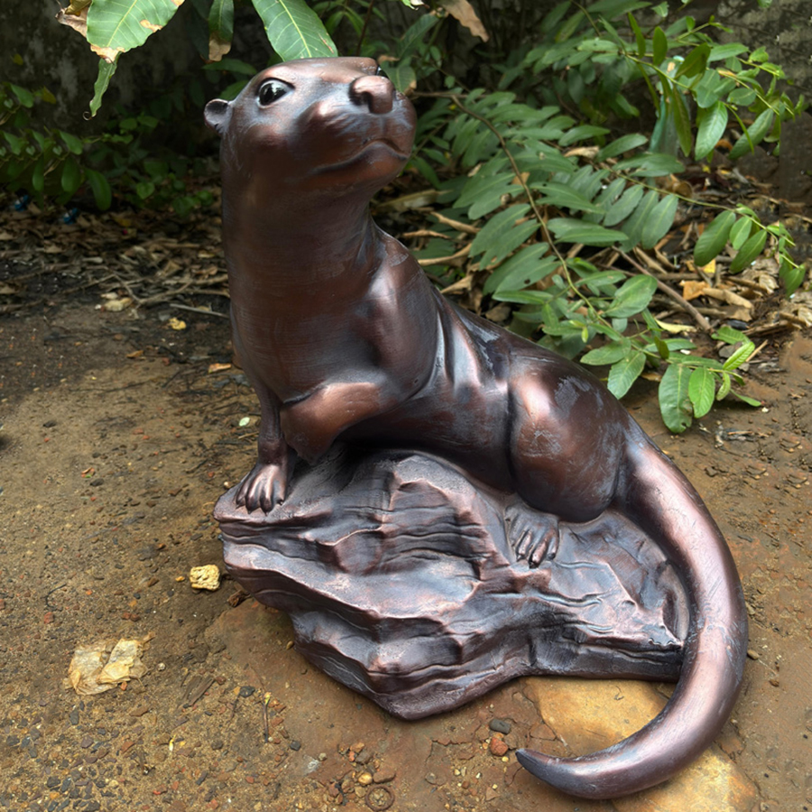 bronze Otter Lawn Ornament on rock