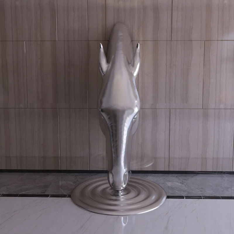stainless steel horse head sculpture emerging from wall