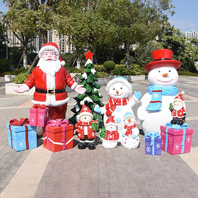 0-Festive outdoor display featuring fiberglass Christmas sculptures, including Santa Claus, snowmen, a decorated Christmas tree, and colorful Gift Box Sculptures