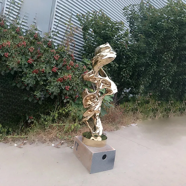 Abstract gold stainless steel sculpture inspired by natural rock forms