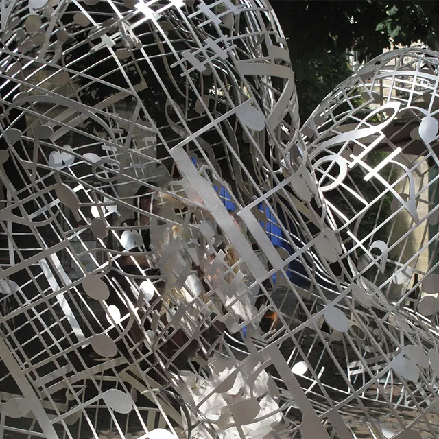 Close-up view of stainless steel Wire Human Figure sculpture featuring musical notes and mesh design