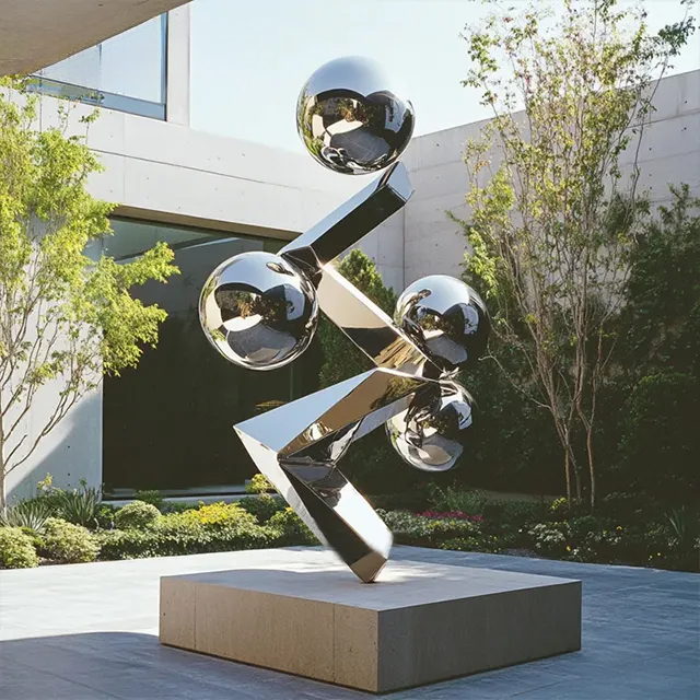 Contemporary stainless steel sculpture featuring polished metal spheres and sharp-edged beams