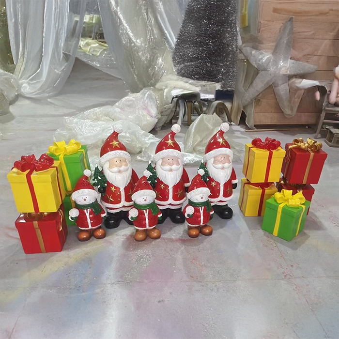 Fiberglass Decorative Snowman Figurine dressed in festive red and green, displayed with Santa Claus figurines and decorative presents