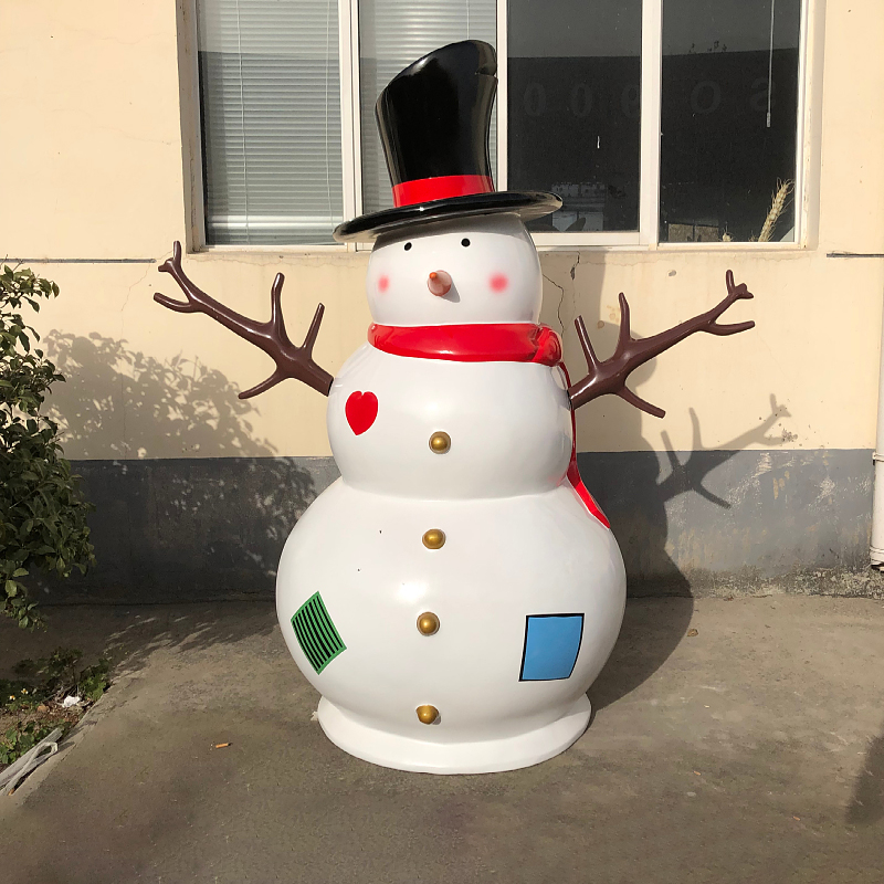 Giant Outdoor Snowman Sculpture crafted from fiberglass, shows a classic snowman with top hat, red scarf, branch arms, and decorative patches