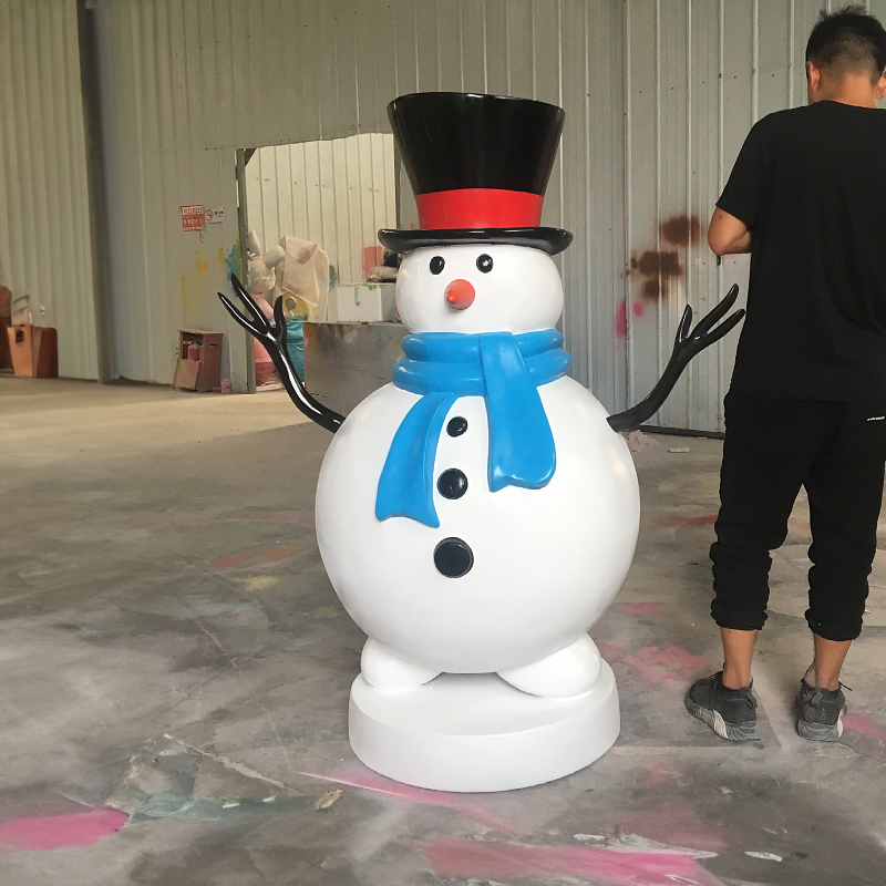 Giant Outdoor Snowman Sculpture made of fiberglass, presents a snowman with black top hat, blue scarf