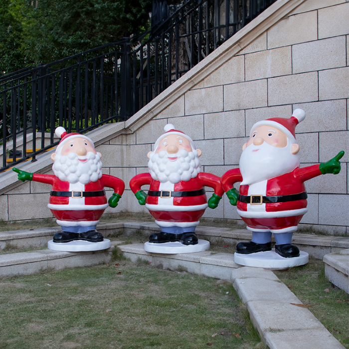 Group of three fiberglass Santa Statue Decorations in cheerful poses