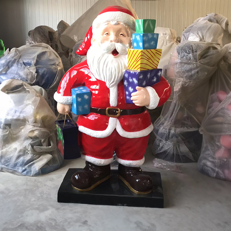 Large Outdoor Santa Statue crafted from fiberglass, has a Santa in red suit holding multiple colorful gifts