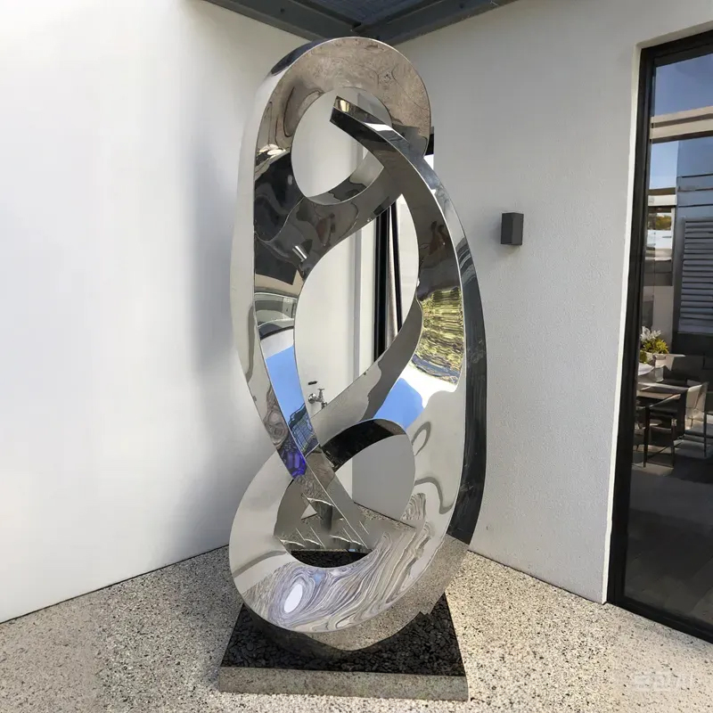 Modern metal statue in stainless steel with two vertical oval rings and inward curving tails