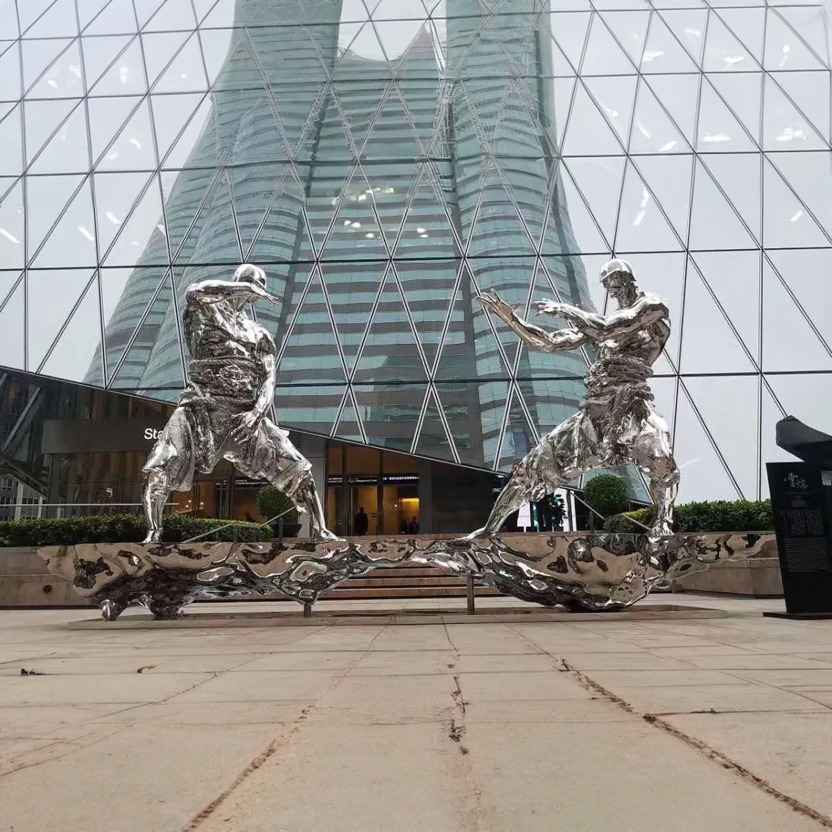 Polished stainless steel Fighting Men Statue showing detailed warrior figures