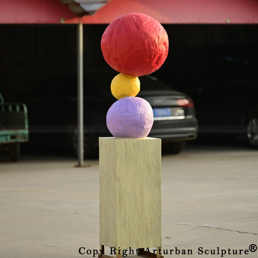 8-Colorful bronze Annie Morris Sculpture featuring a red sphere, yellow sphere, and purple sphere balanced on a square base