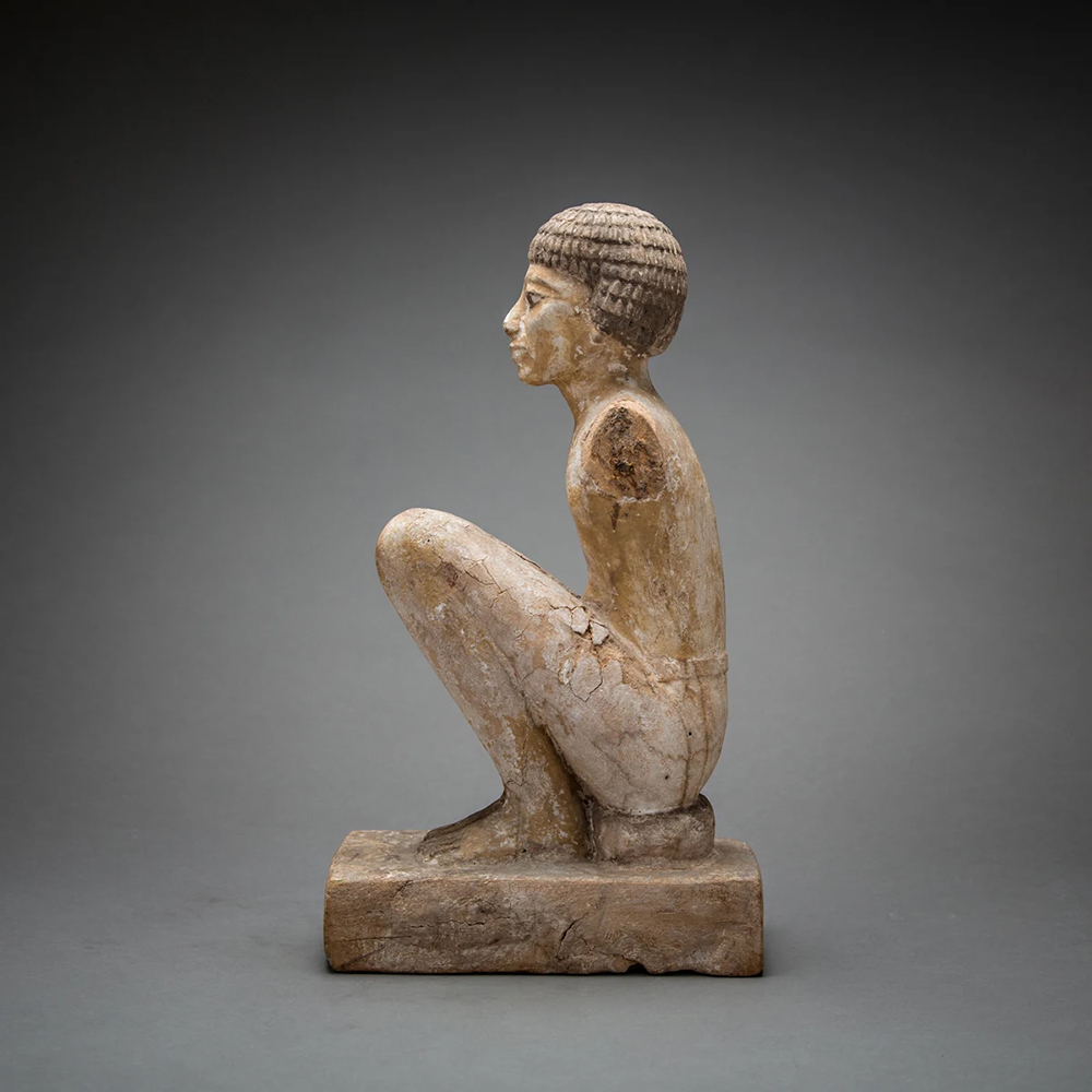 gyptian figure sculpture with solemn expression