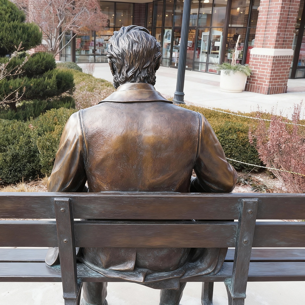 Abraham Lincoln Bronze Statue back view on park bench