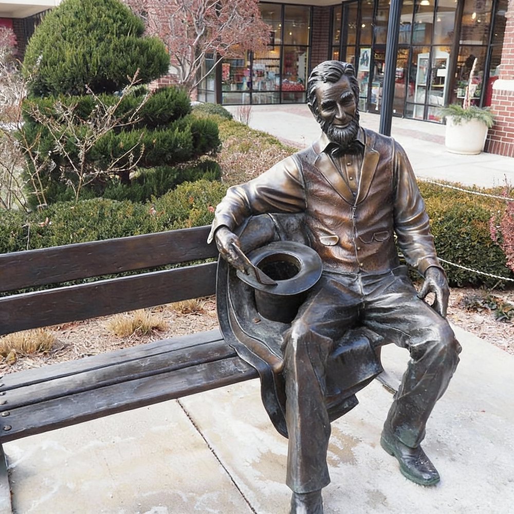 Abraham Lincoln Bronze Statue seated on bench holding hat