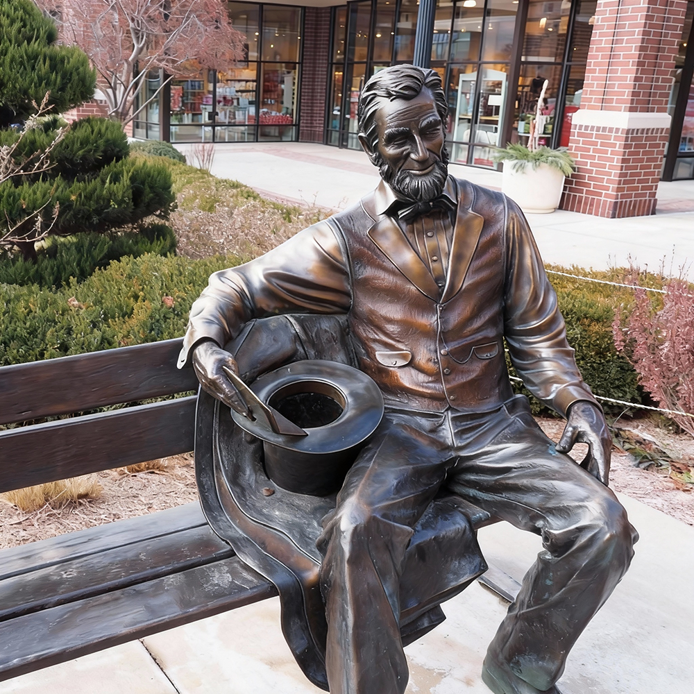 Abraham Lincoln Bronze Statue back view on park bench
