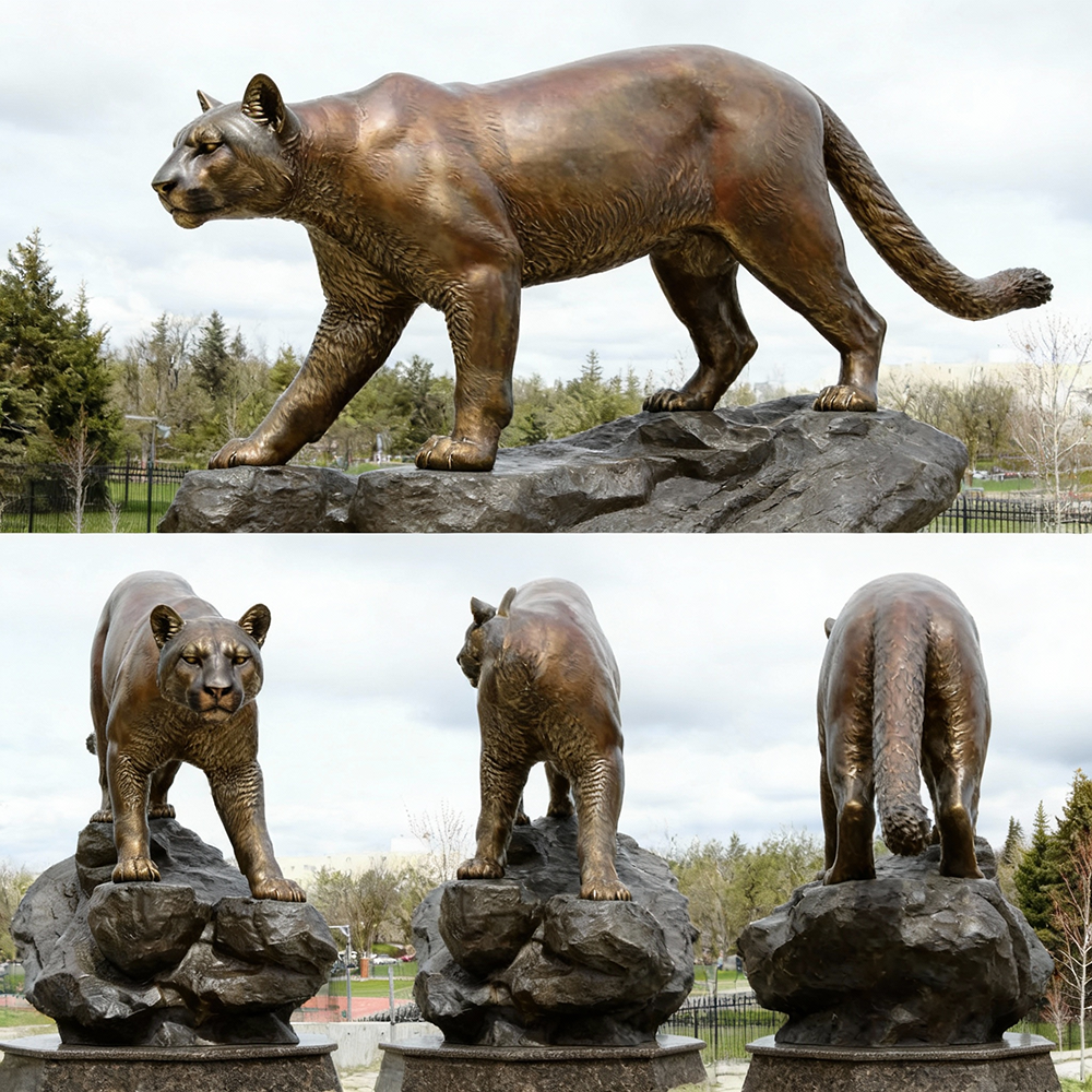 Bronze Puma Sculpture walking on rocky base outdoors