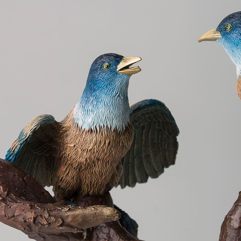 bronze magpie sculpture with wings open singing