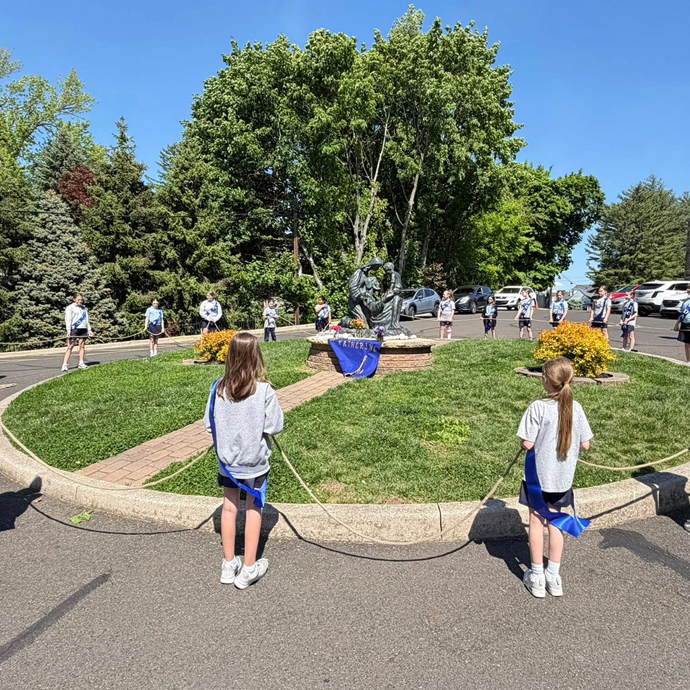 2.5-Students Praying Around Holy Family Statue