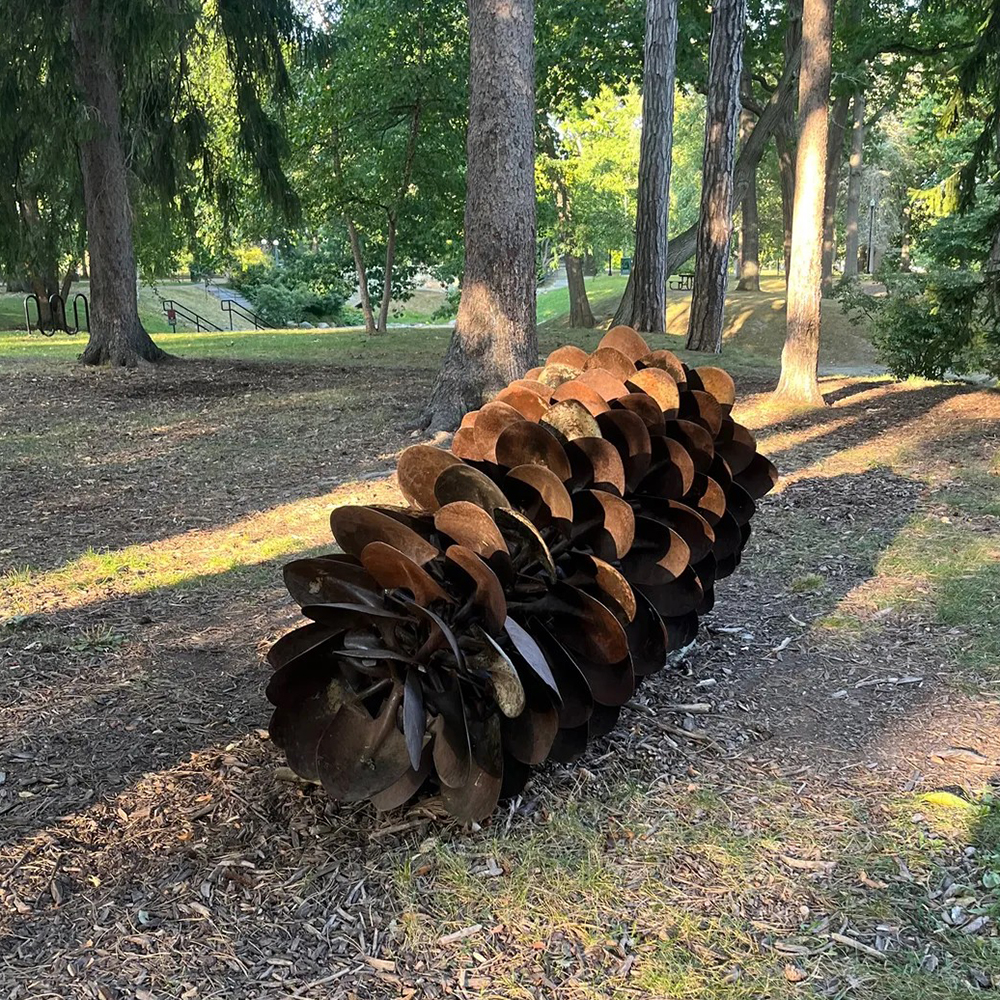 Outdoor pine cone large sculpture among trees