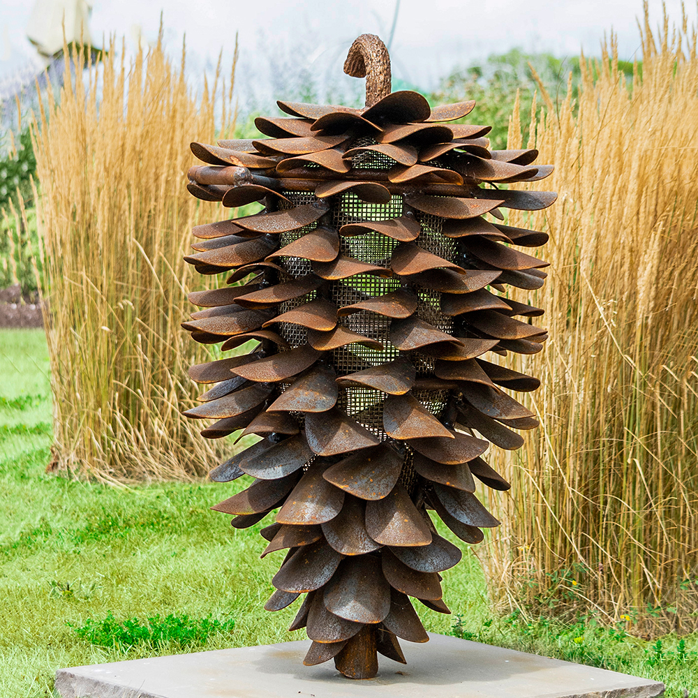 Rusty pine cone art sculpture in garden