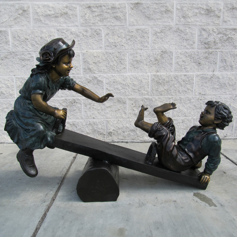 Bronze Kids on Seesaw Sculpture in Park