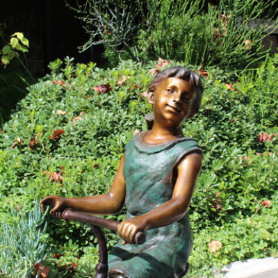 Front Bronze Girl Riding Tricycle Sculpture display