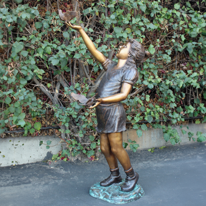 Girl Holding Birds Statue in Garden