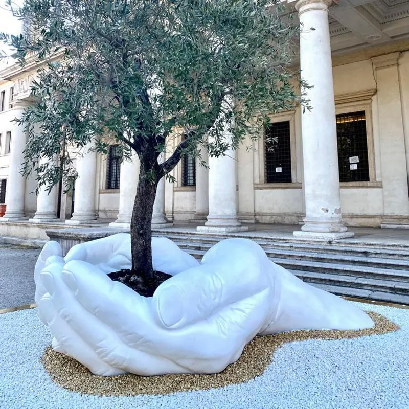 Marble hands holding tree sculpture