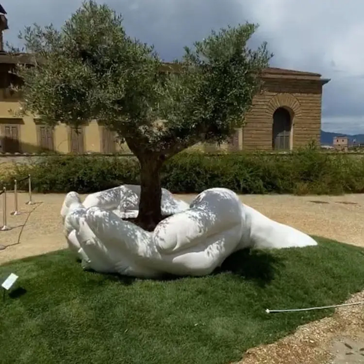 White marble hands supporting olive tree