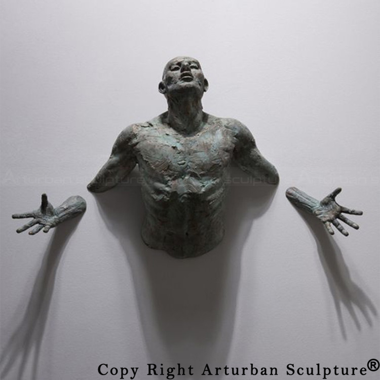 2 Side view of man breaking through wall sculpture