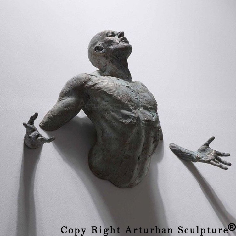 3 Bronze man breaking through wall sculpture front view