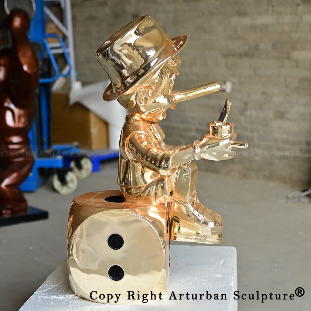 7 Golden Pinocchio sculpture seated sideways on dice