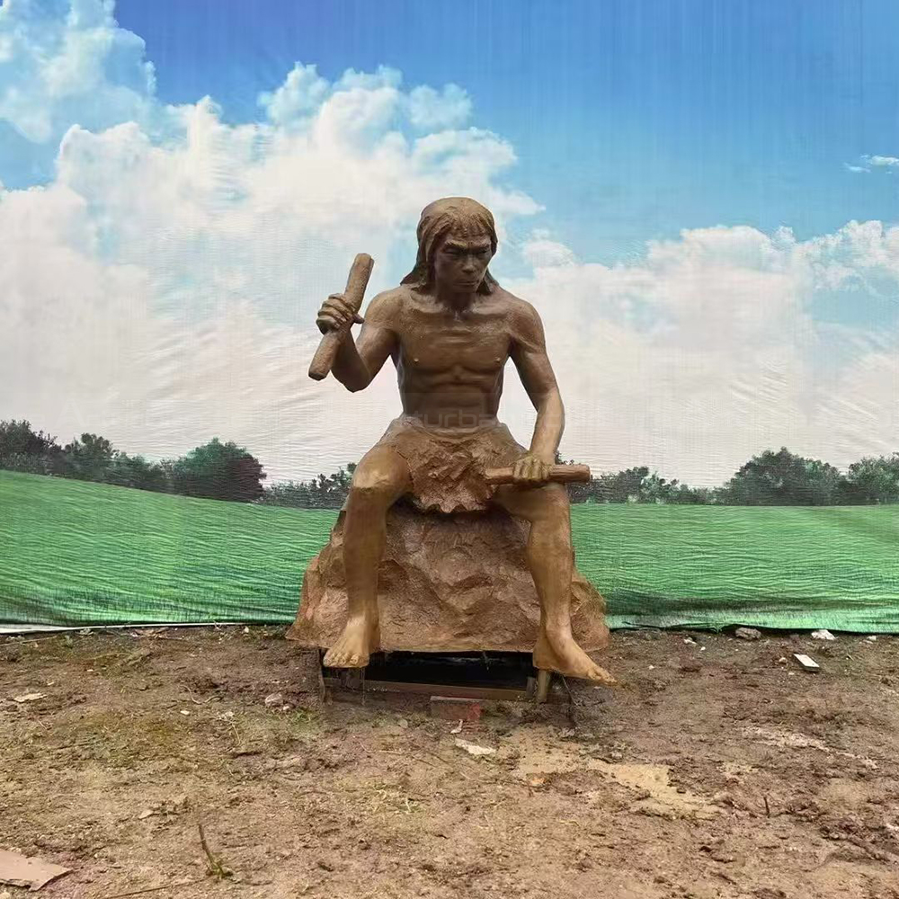 Fiberglass Caveman Sculpture shaping tools while seated