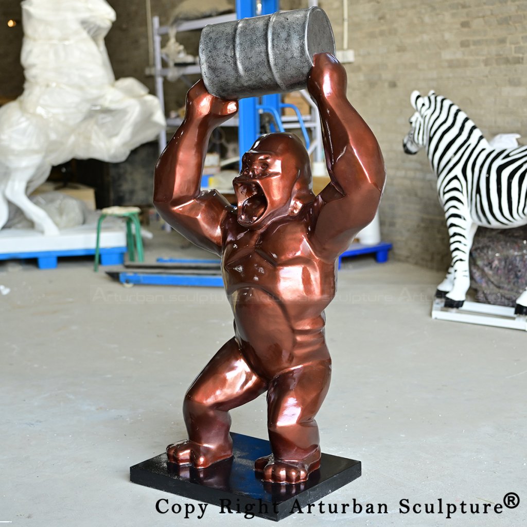 7 Bronze gorilla sculpture lifting metal oil barrel