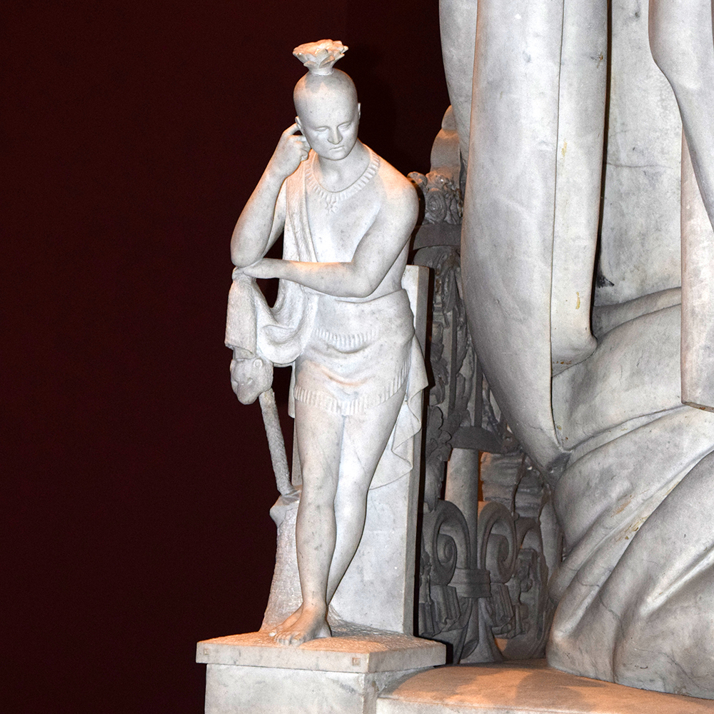 Carved Native American figure beside marble throne