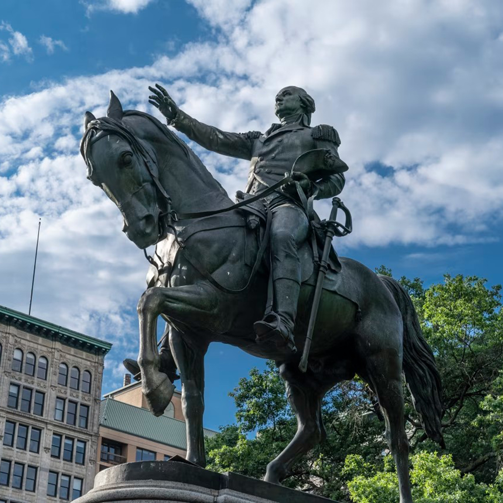 George Washington statue in bronze beneath blue sky