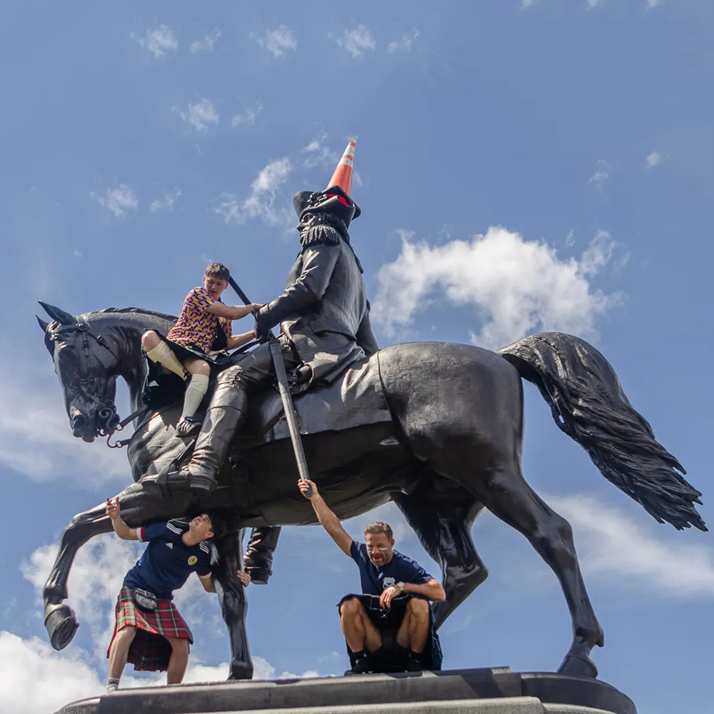 George Washington statue with fans and traffic cone